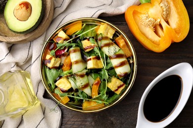 Photo of Delicious salad with tofu, vegetables and balsamic vinegar served on wooden table, flat lay