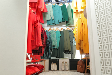 Photo of Different stylish clothes and shoes in dressing room. Fashion blogger