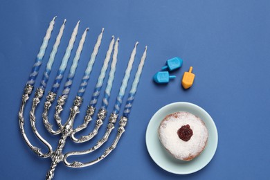 Photo of Flat lay composition with Hanukkah menorah on blue background
