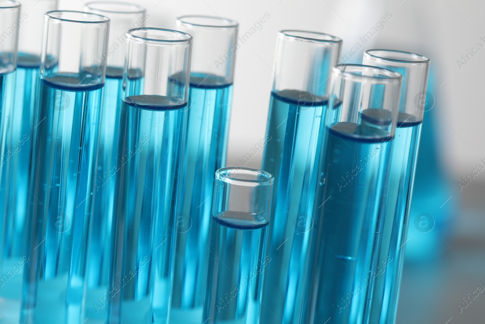 Photo of Test tubes with light blue liquid in laboratory, closeup
