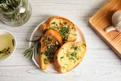 Flat lay composition with tasty homemade garlic bread on table