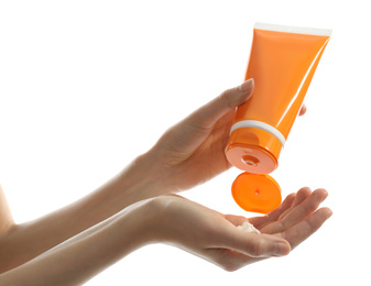Woman applying sun protection cream on hand against white background, closeup