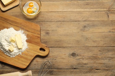 Photo of Board with fresh butter and flour on wooden table, flat lay. Space for text