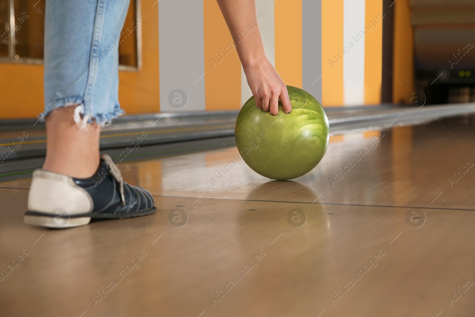 Photo of Young woman throwing ball in bowling club, club