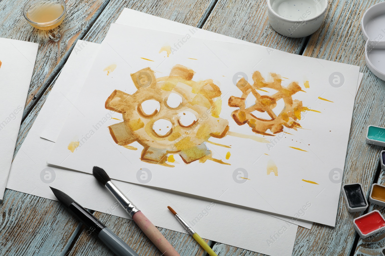 Photo of Composition with watercolor painting of gears and paints on light grey wooden table