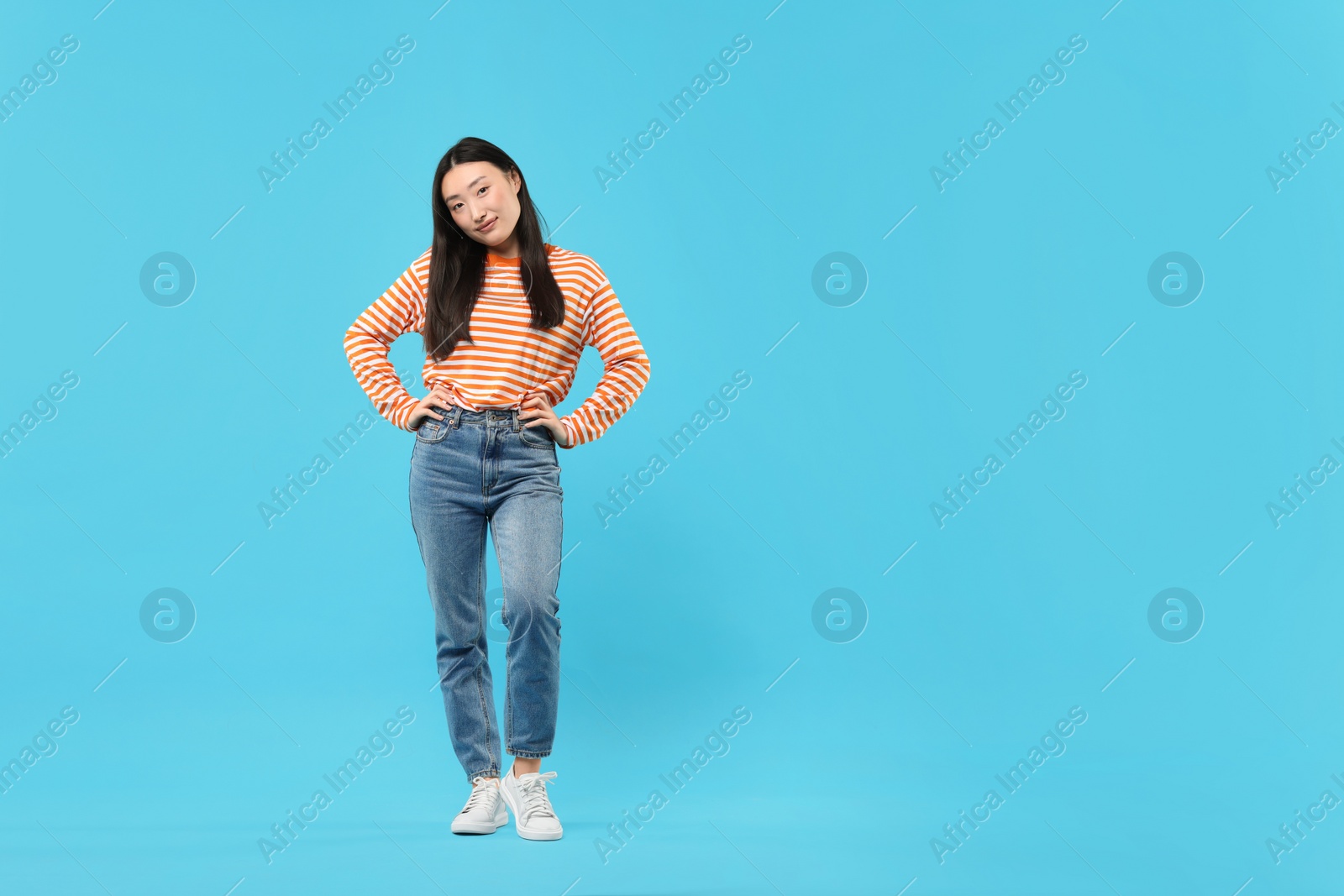 Photo of Full length portrait of cute woman on light blue background. Space for text