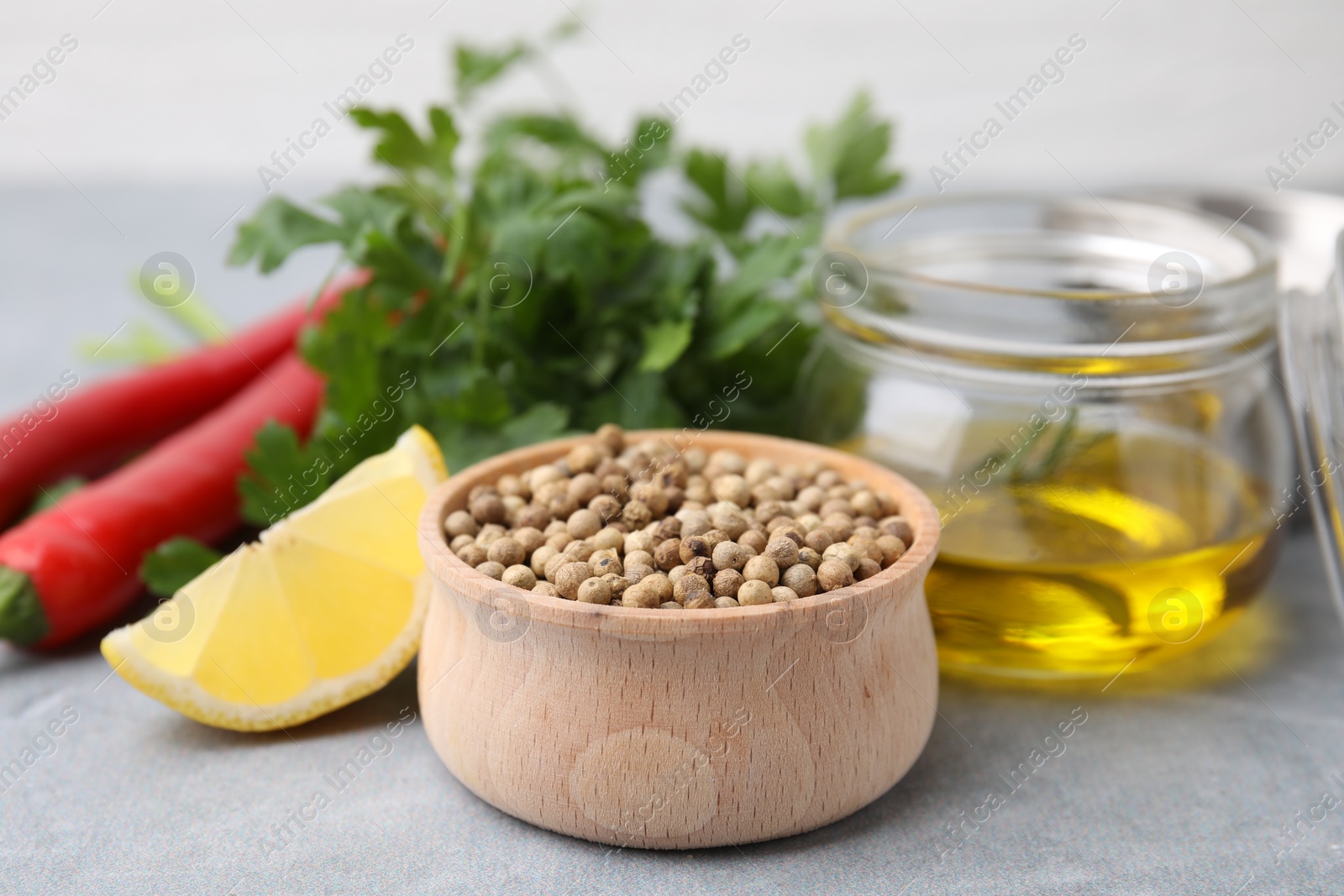 Photo of Aromatic peppercorns and different fresh ingredients for marinade on grey table