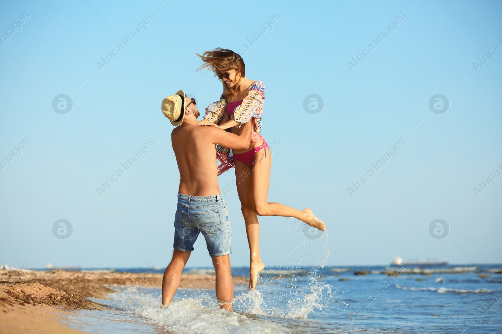 Photo of Young couple spending time together on beach