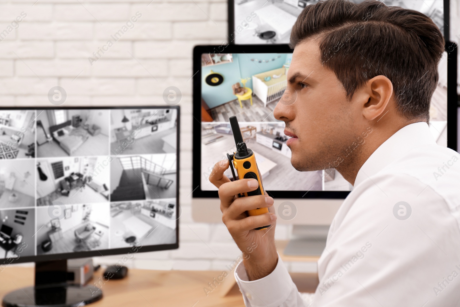 Photo of Male security guard with portable transmitter at workplace