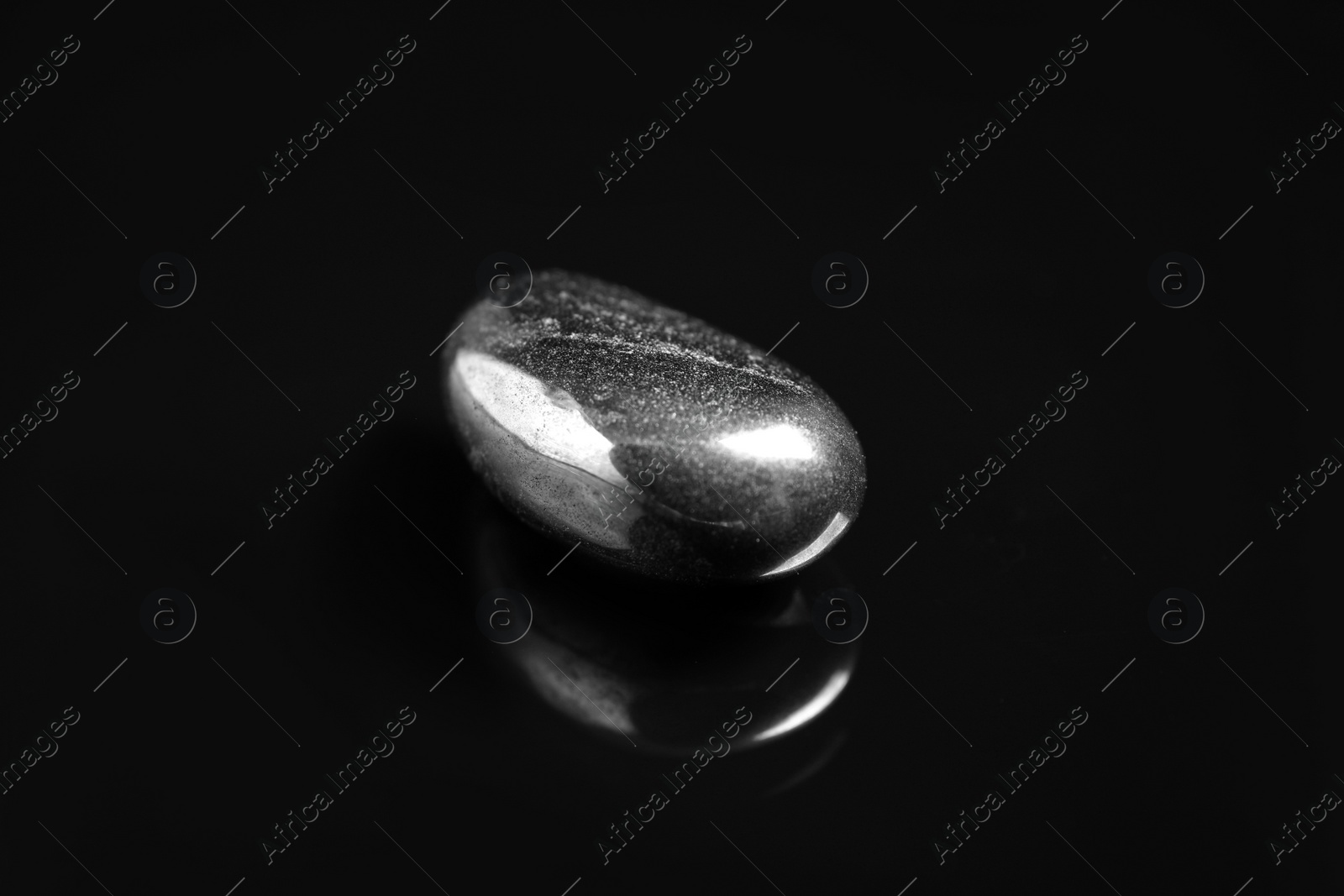 Photo of Beautiful shiny hematite gemstone on black background