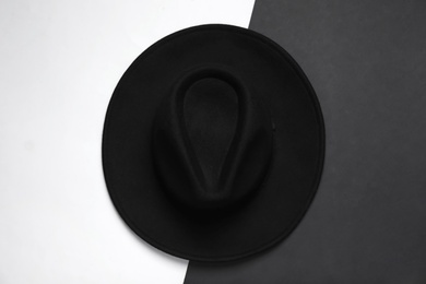 Photo of Elegant black hat on color background, top view