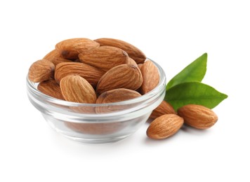 Glass bowl with organic almond nuts and green leaves on white background. Healthy snack