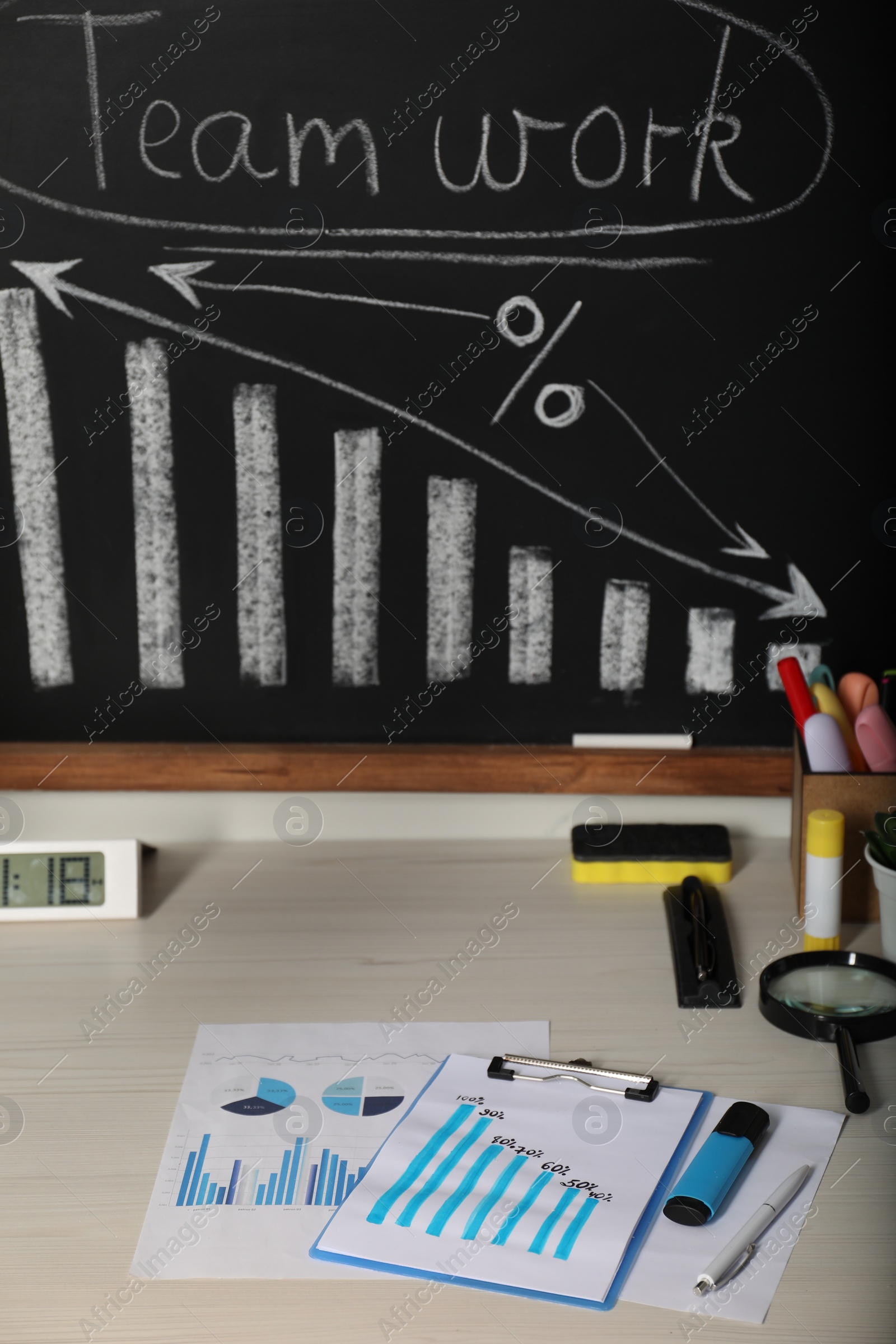 Photo of Business process planning and optimization. Workplace with blackboard, graphs and other stationery on wooden table