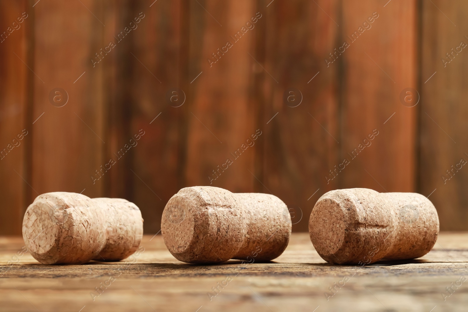 Photo of Corks of wine bottles on wooden table, closeup