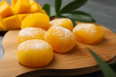 Photo of Delicious mango mochi on wooden board, closeup