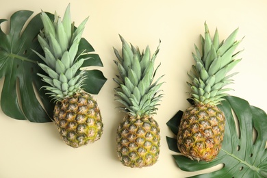 Photo of Fresh ripe juicy pineapples on beige background, flat lay