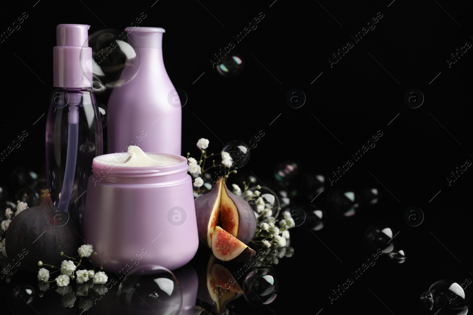 Photo of Composition with hair cosmetic products and soap bubbles on black background. Space for text