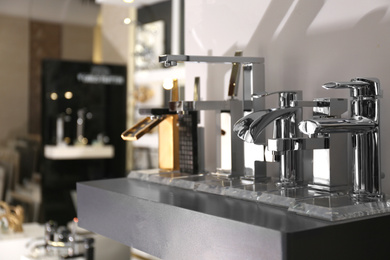 Photo of New shiny faucets in bathroom fixtures store. Total wholesale