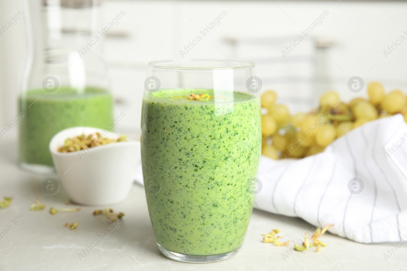 Photo of Green buckwheat smoothie on light grey marble table