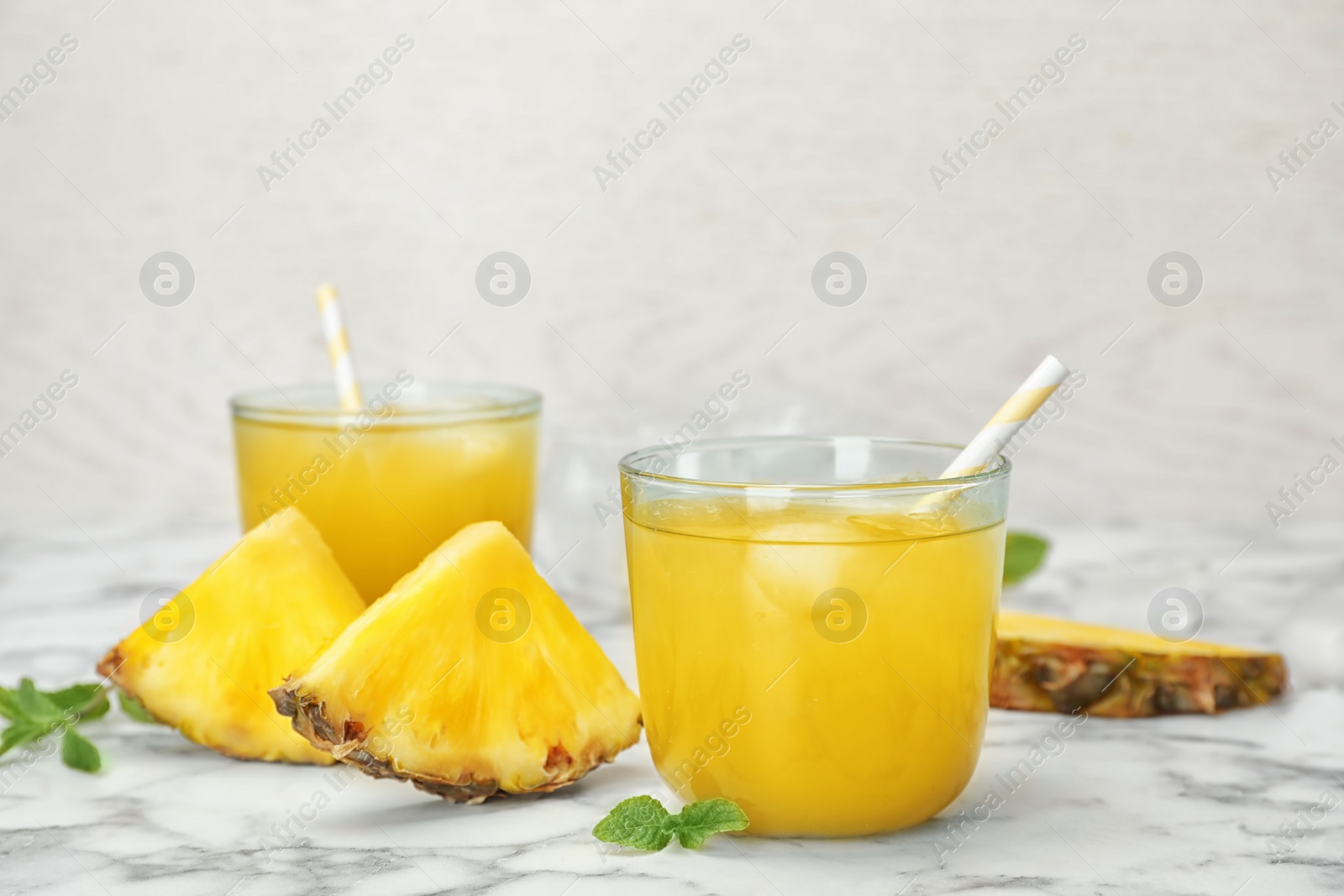 Photo of Glasses with delicious pineapple juice on table