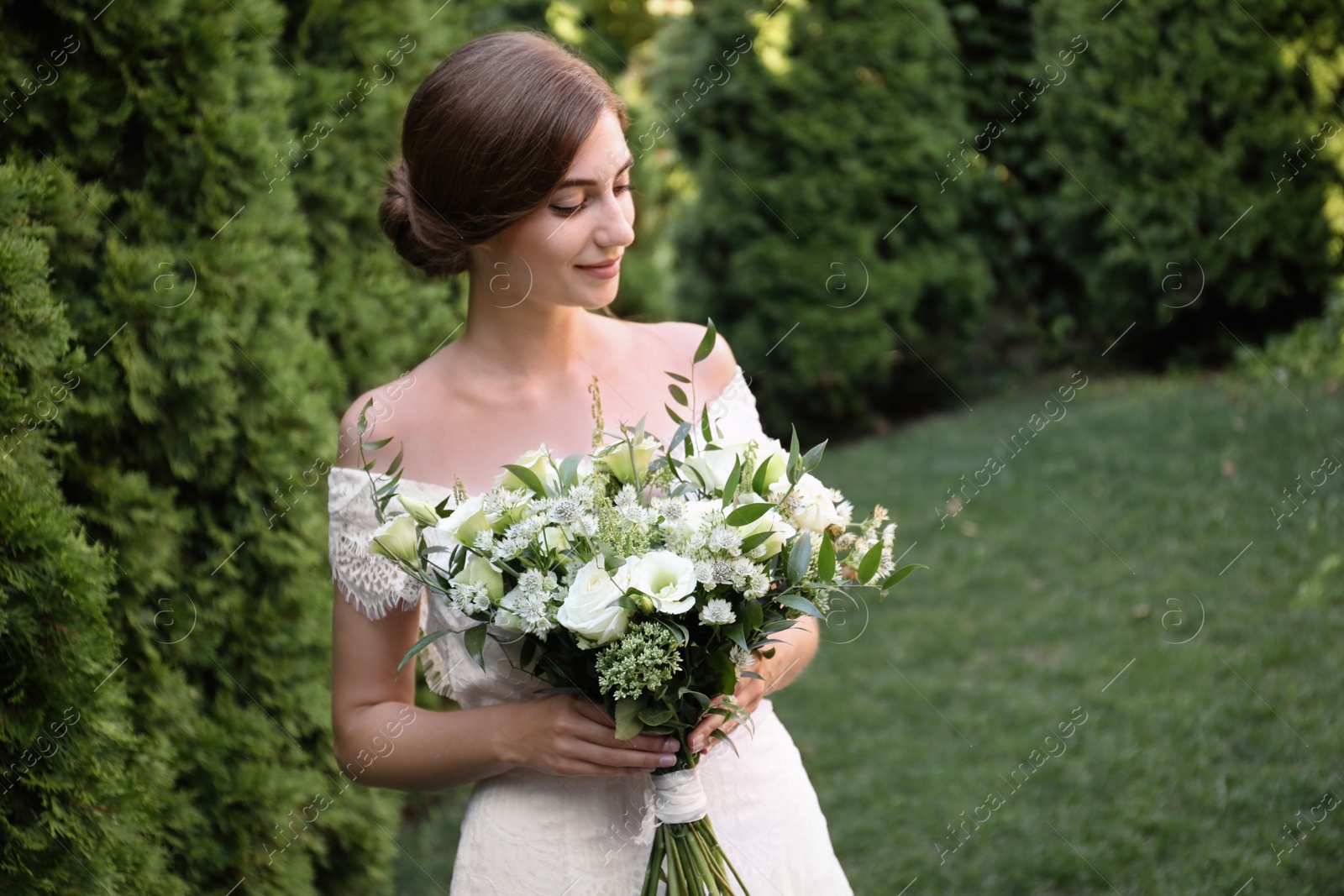 Photo of Gorgeous bride in beautiful wedding dress with bouquet outdoors