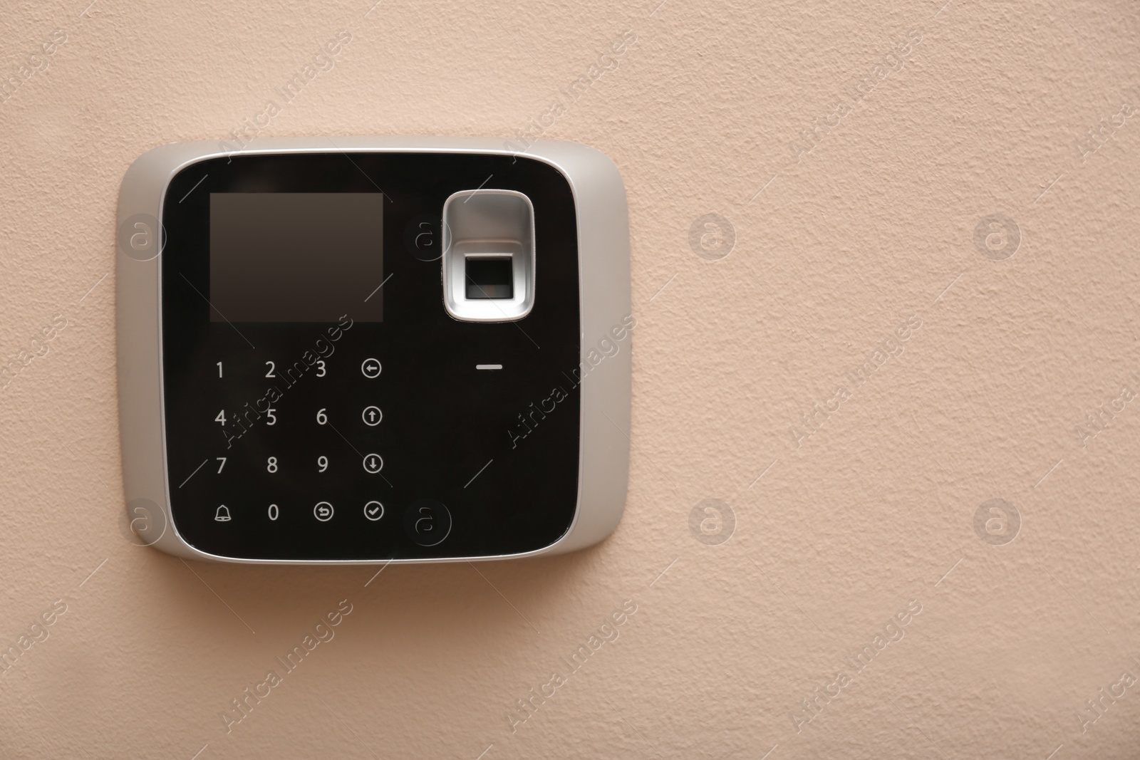 Photo of Modern alarm system with fingerprint scanner on color wall. Space for text