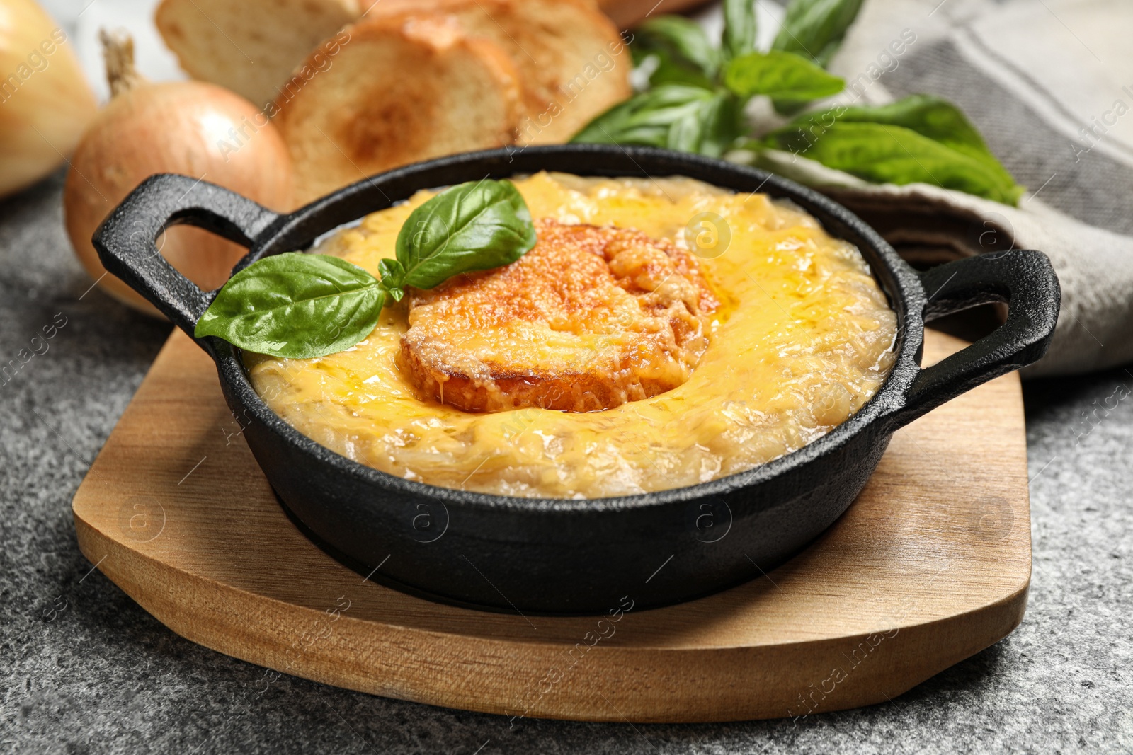 Photo of Tasty homemade french onion soup served on grey table