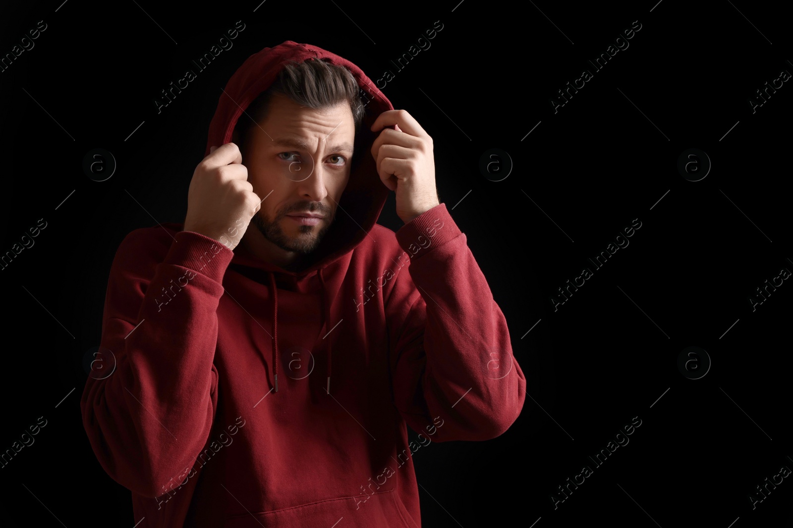 Photo of Portrait of sad man on black background. Space for text