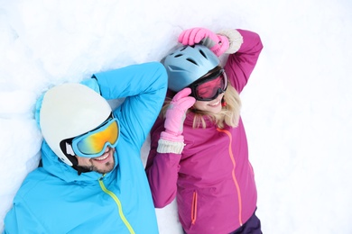 Photo of Couple lying on snow at ski resort. Winter vacation