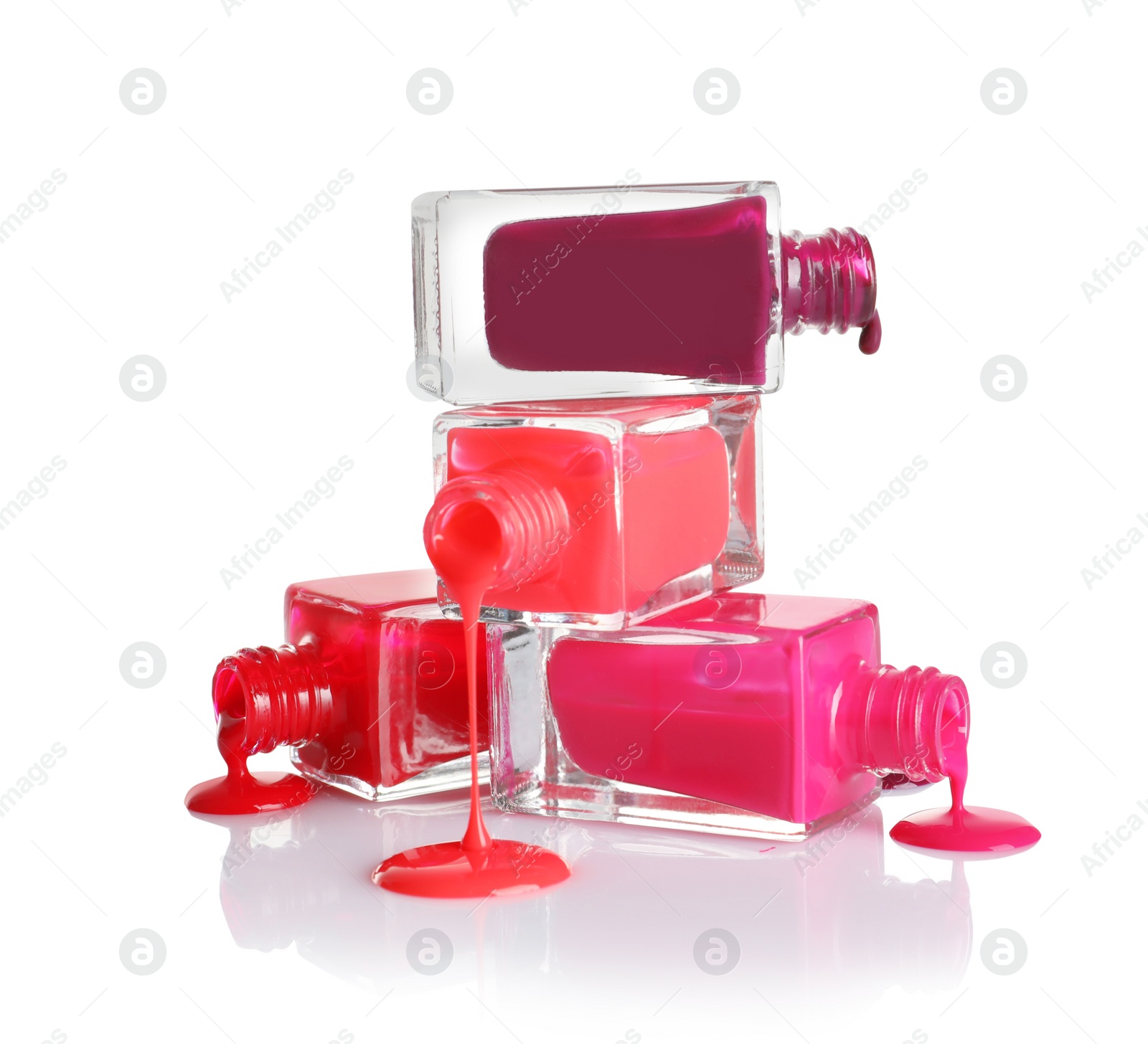 Photo of Spilled different nail polishes with bottles on white background