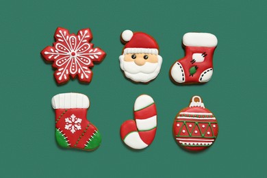 Different tasty Christmas cookies on green background, flat lay