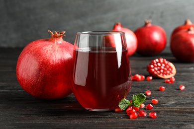 Glass of pomegranate juice and fresh fruits on table against grey background