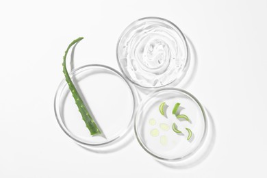 Photo of Petri dishes with aloe plants and cosmetic product on white background, top view