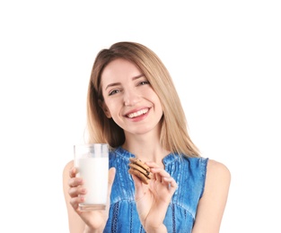 Beautiful young woman drinking milk with cookies on white background