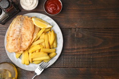 Delicious fish and chips served on wooden table, flat lay. Space for text