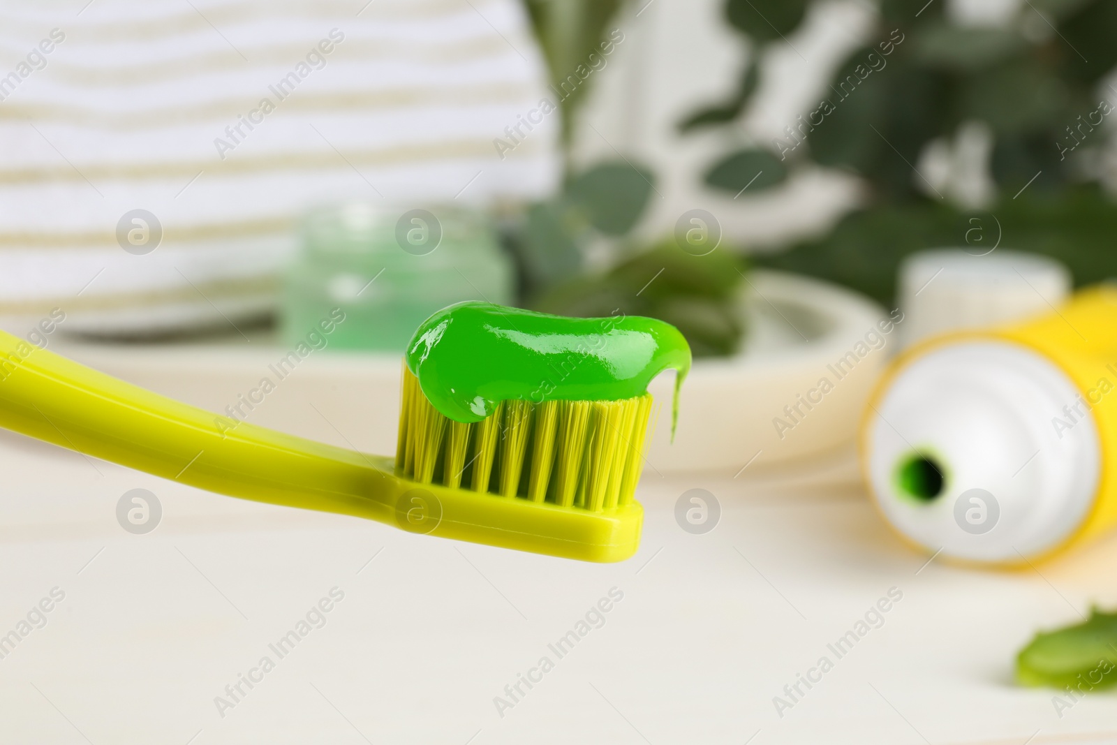 Photo of Toothbrush with aloe toothpaste on blurred background, closeup