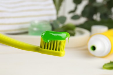 Toothbrush with aloe toothpaste on blurred background, closeup