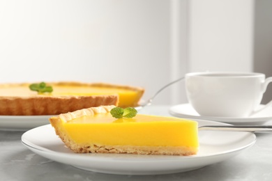 Slice of delicious homemade lemon pie on grey table