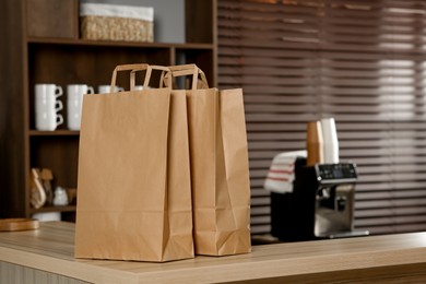 Photo of Paper bag on wooden counter in cafe, space for text