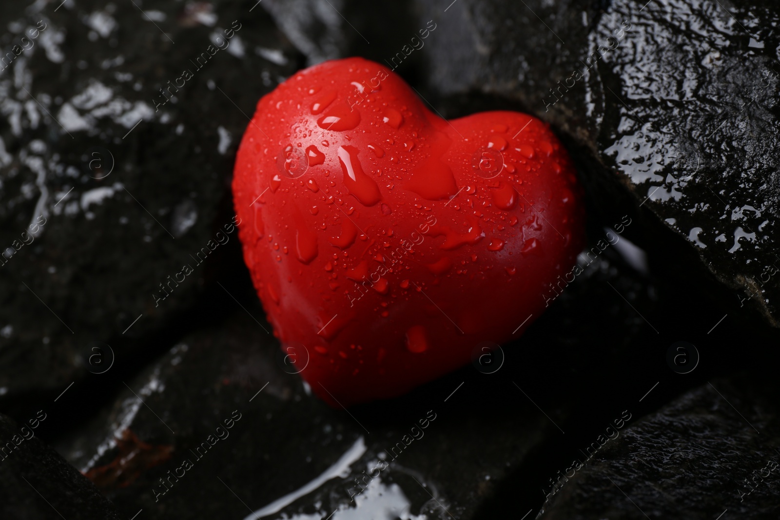 Photo of Red decorative heart on stones, closeup view