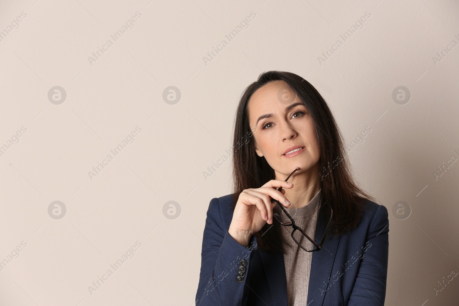 Photo of Portrait of beautiful mature woman with glasses on beige background. Space for text