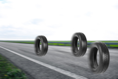 Car tires rolling on asphalt highway outdoors