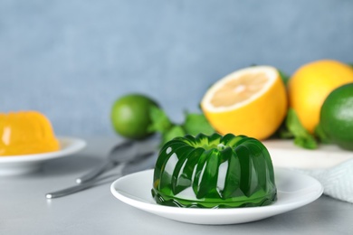 Photo of Delicious fresh green jelly on grey table, space for text