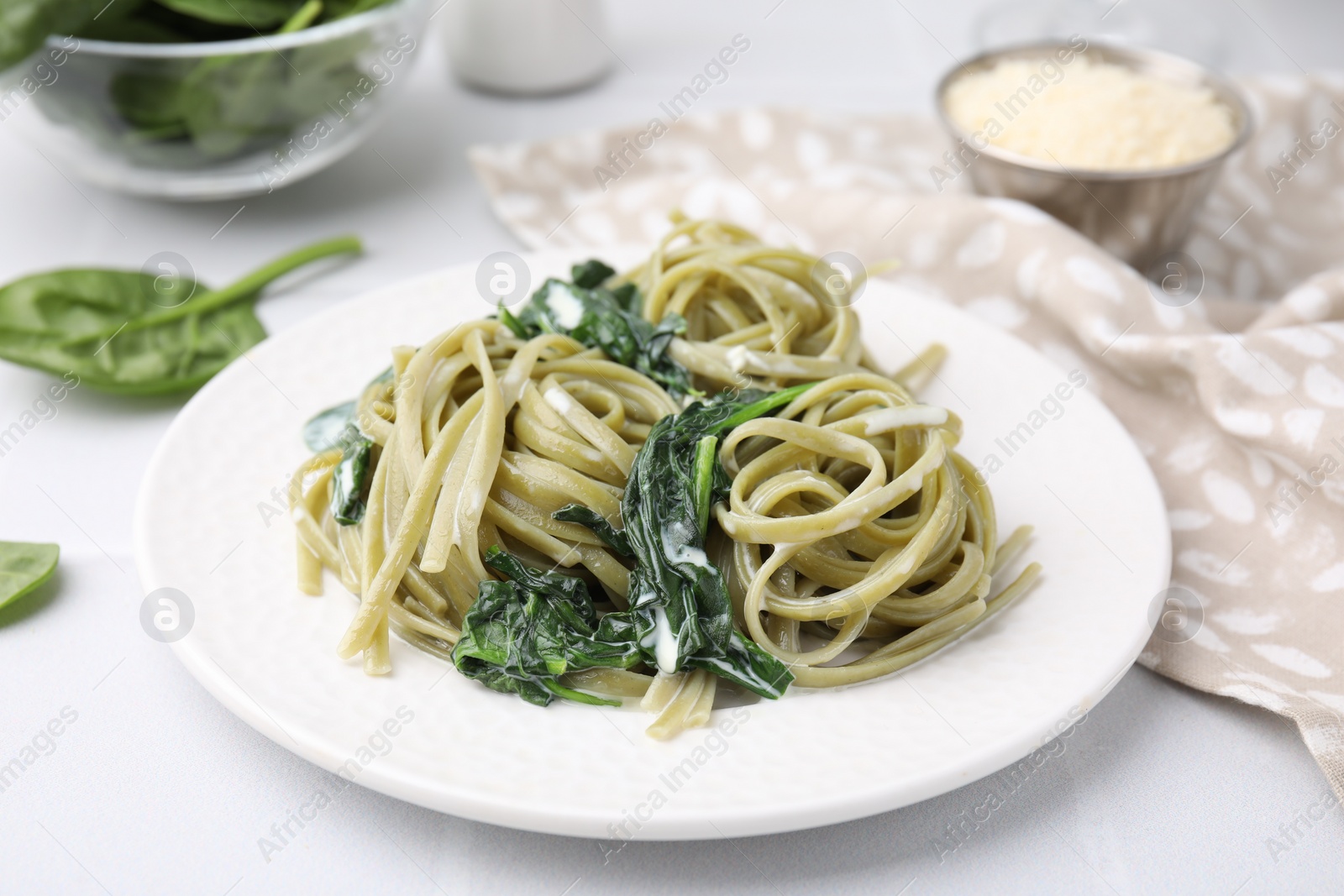 Photo of Tasty pasta with spinach and sauce on white table