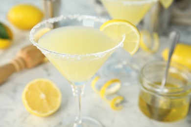 Photo of Delicious bee's knees cocktail and ingredients on white table, closeup