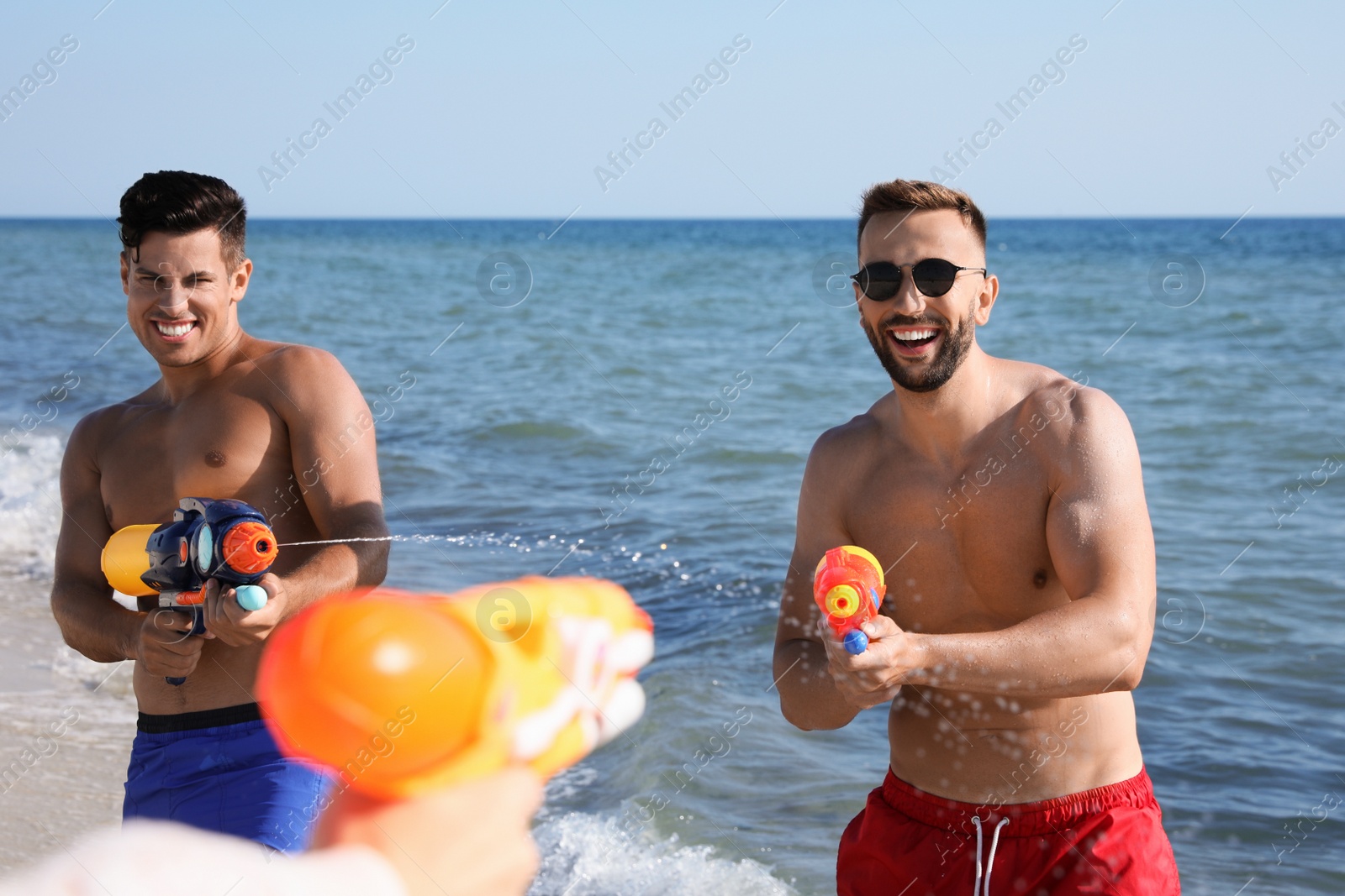 Photo of Friends with water guns having fun on beach