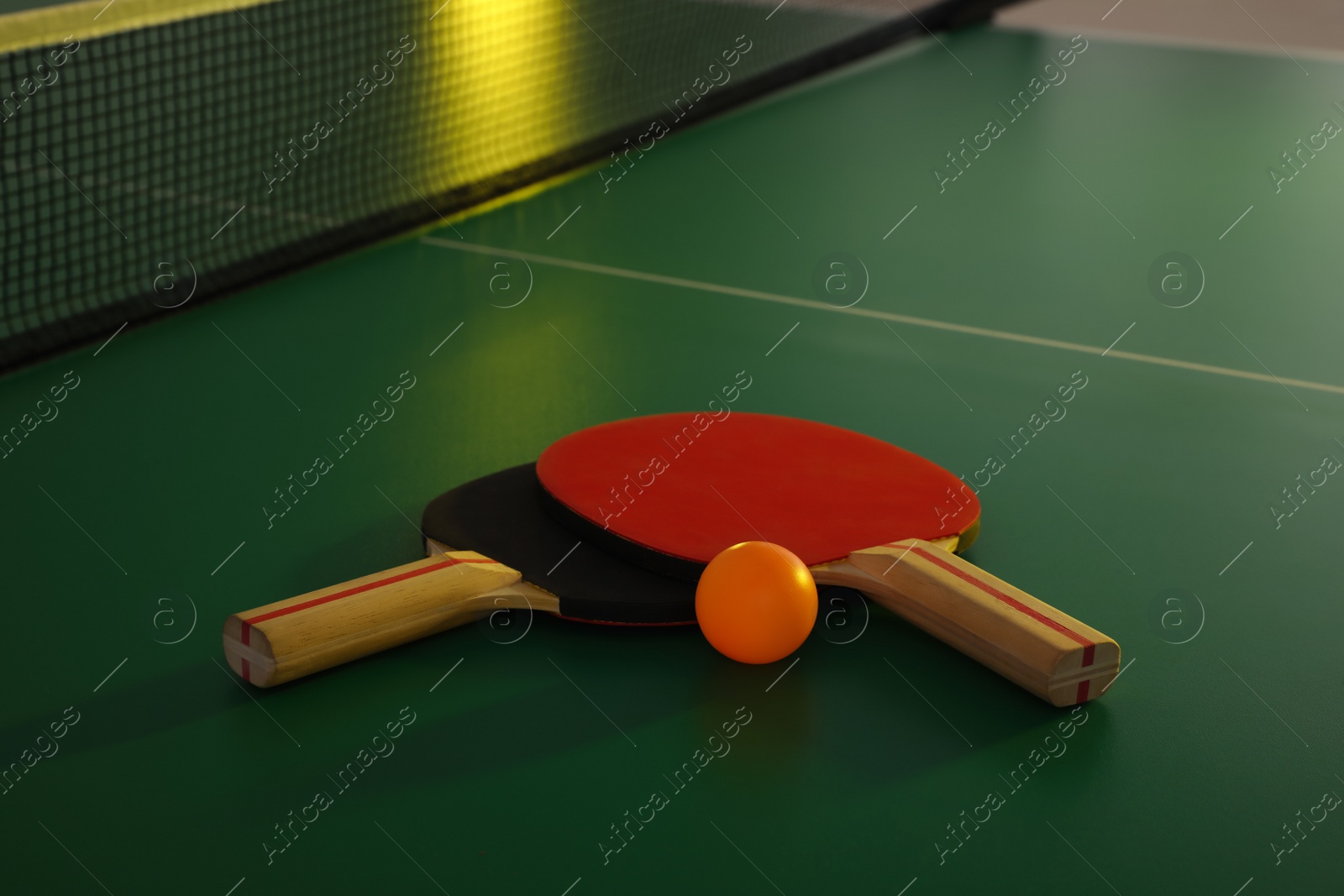 Photo of Rackets and ball on ping pong table