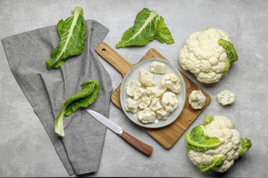 Cut and whole cauliflowers on grey table, flat lay