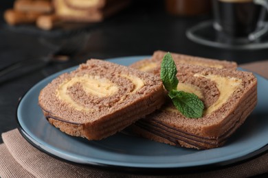 Photo of Tasty chocolate cake roll with cream on napkin, closeup