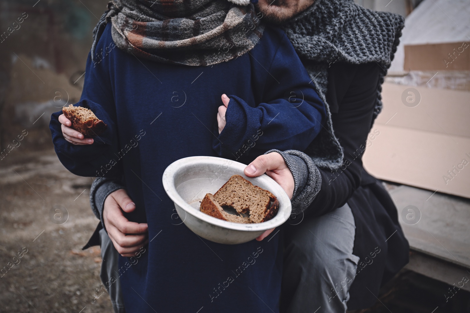 Image of Poor father and child with bread at dump, closeup